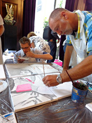 Workshop puzzelschilderij, schilderij maken bestaande uit een aantal kleine doeken, een foto wordt in stukken geknipt, iedereen krijgt een puzzelstukje, samen wordt dit een groot schilderij, in di geval met het thema reiziger voor de ns